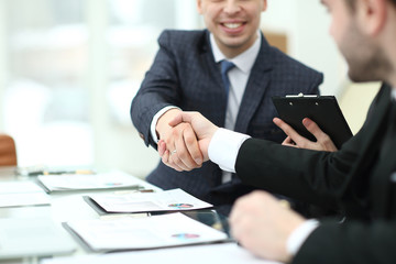 handshake of financial partners at the Desk