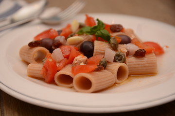 pasta con pescespada pomodori capperi olive nere uva sultanina basilico piatto tipico della sicilia sud italia sapori mediterranei