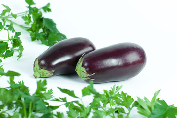 closeup.eggplants and sprigs of parsley isolated on white background