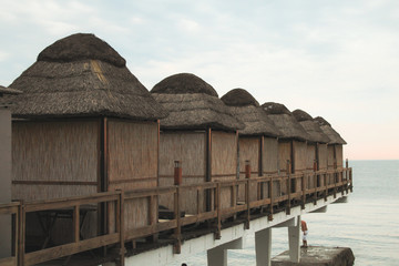Bungalows for relaxation and privacy on the sea at sunset.