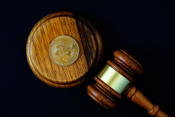 Bitcoin coin and judges gavel on a black background,  concept of legitimacy,  legalization of cryptocurrency.