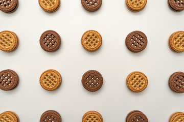 Wallpaper. Close-up of chocolate and vanilla cookies with cream on a white background. View from above