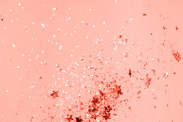 Living Coral pastel confetti and sparkles background, golden stars. Bright and festive. Color of the year 2019 16-1546. Copyspace for text.