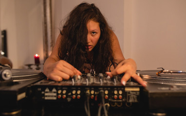 Fototapeta na wymiar Junge DJ Frau am Mischpult Turntable Plattenspieler