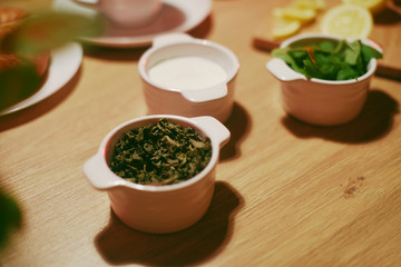 Green tea, sugar and mint in bowls on a wooden table. Pickled tea, Herbal Tea Leaf