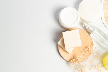 herbal with soap and spray bottle with facial cream with wood dish and dried flower in top view
