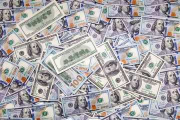 One hundred dollar bills on the table as background