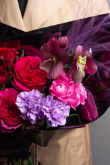 interesting bouquet of fresh flowers in a beautiful black wrapper in female hands