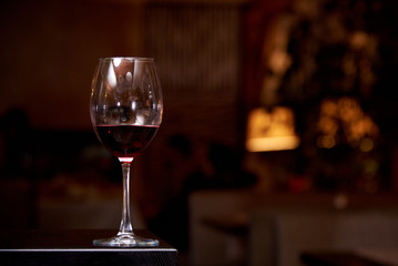 A glass of red wine on a dark background. Copy space.