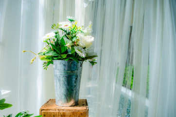Flowers in aluminum vases are set on wooden crates.