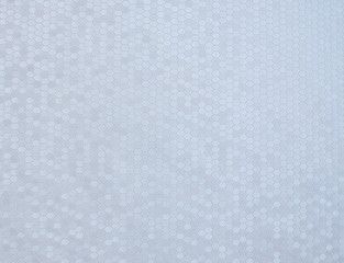 Texture of artificial radiant skin with honeycomb perforation. Abstract background, defocus.