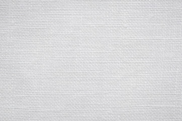 White canvas background. White linen texture. Cotton fabric with fibers, close-up.