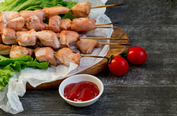 Chicken breast skewers cooked in homemade oven with red and white sauce and tomatoes.