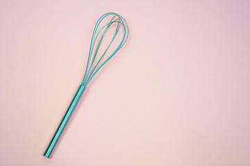  whisk on  pink pastel background. Top view, minimalism