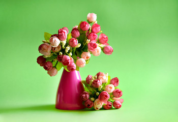 Pink vase with a bouquet of artificial flowers of roses
