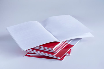 Pile of advertising magazines on a white background.