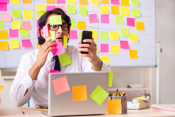 Young employee in conflicting priorities concept 