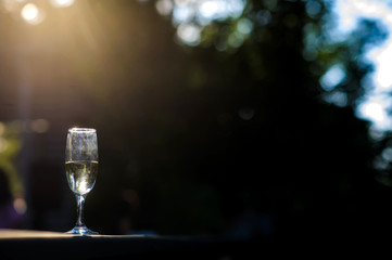 close up photo of a glass of champagne on the sunrise background