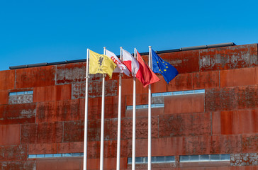 Flag posts, poles with rusty steel building of European Solidarity Centre in Gdansk, Poland. - obrazy, fototapety, plakaty