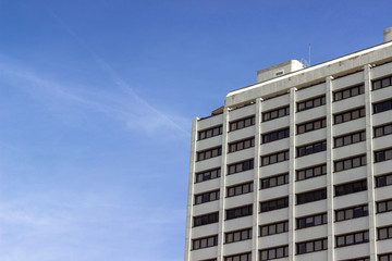 Perspective bottom shoot of modern reinforced concrete building with blue air