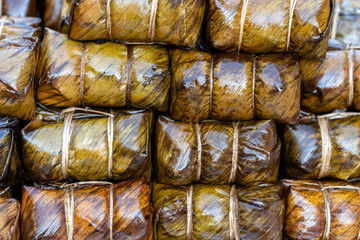 Deep fried chicken wrapped in green pandan leaves at street food market in Thailand. Thai food concept