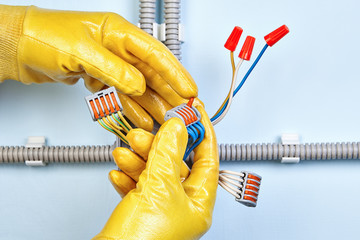 Worker installs junction box with wist-on wire connectors.