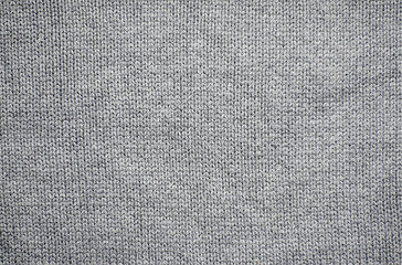 Knitted fabric background. The texture of grey woolen fabric.