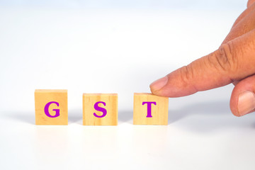Hand hold a GST word on wooden cube block.business concept.