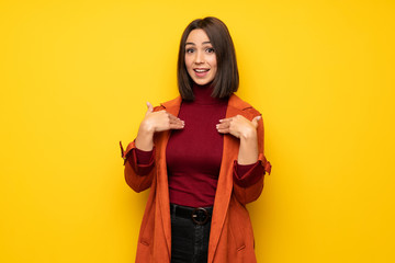 Fototapeta premium Young woman with coat with surprise facial expression