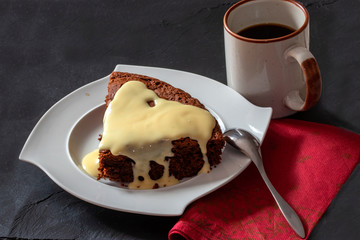 Part de gâteau au chocolat et crème pâtissière dans une assiette blanche
