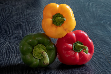 Poivrons de couleurs différentes sur fond sombre