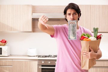 Young handsome man with vegetables in the kitchen 