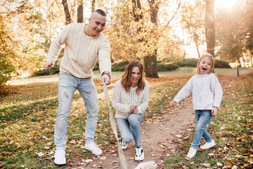 Fototapeta premium Happy family is having fun with dog labrador outdoors.