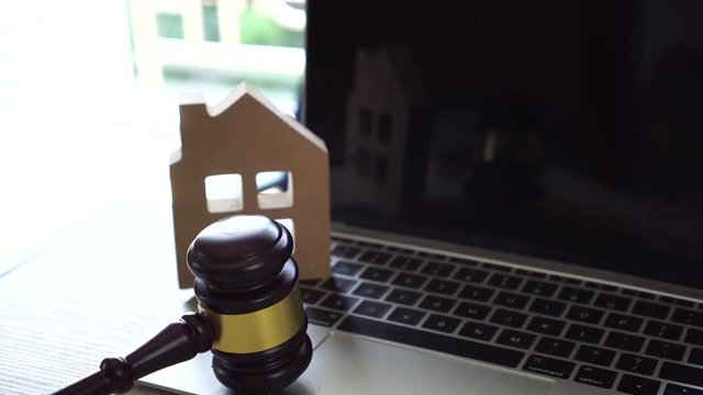 Online Auction for Real Estate home ownership, buying selling or foreclosure concept. Judge gavel house model on computer. Idea for housing business judgment by E-commerce online digital over internet