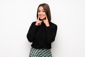 Young woman over white wall smiling with a happy and pleasant expression