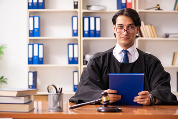 Obraz na płótnie Canvas Young handsome judge working in court 
