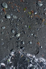 image of black sand with stones