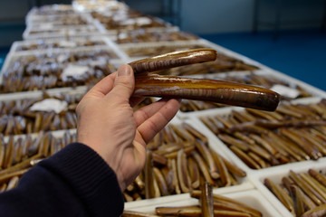 image of a person with razor of the sea  in his hand, in a fish shop