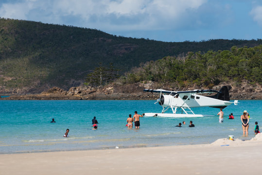 Strand mit Touristen und Wasserflugzeug