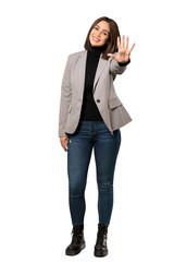 A full-length shot of a Young business woman counting five with fingers over isolated white...