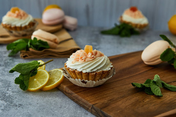 Obraz na płótnie Canvas Cake basket with cream and lemon on a wooden board. 