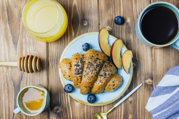 Breakfast served with croissants, coffee, orange juice and berries.