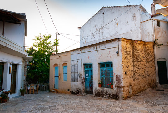 An old colorful house and an alley bathed in sunlight in Greece