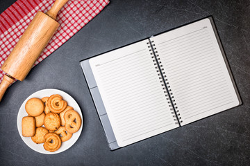 Cookies on Plate and Diary book with Black stone table background.