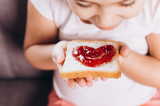Children hand's holding sandwich with jam 