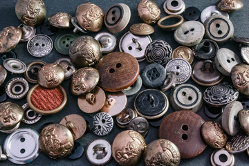 Collection of vintage clothing buttons. Dark stone background, grunge photo.