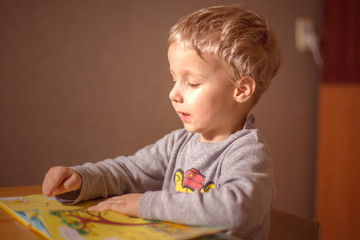 little child learns to read a book