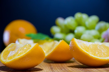 Orange slices and grapes on a wooden Board. Beautiful background of a set of fruits.