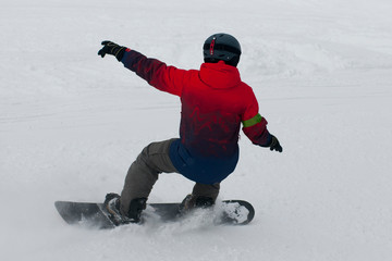 Fototapeta na wymiar snowboarder in ski equipment rides from the mountain