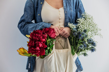 Female hands holding bouquet of peonies, babys breathand and Leucadendron